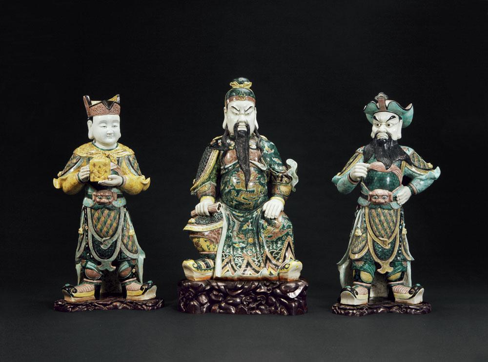 记录:香港苏富比1997年11月4-5日,编号1581 说明:大体量素三彩瓷塑关羽、关平及周仓造像一套三件,烧造技术繁复,且保存至今未佚,极为难得。 所塑关羽头系扎巾,内着盔甲,外批战袍,右手持《春秋》支于膝盖之上,左手抚右膝,神情严肃,不怒自威。一旁关平双手捧印,周仓左手扶腰,右手作持刀状,站立关羽两侧。塑造人物身姿威武,神态自然,动作生动,彩绘纹饰细腻,并忠实罗贯中《三国演义》于关羽衣色描写,以鹦哥绿色为主色调,选取素三彩瓷器品种塑造三人塑像,用心独具。 关羽(?
